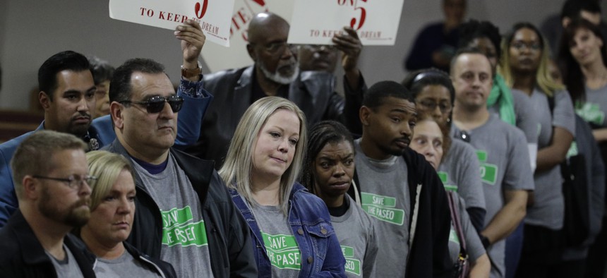 In this Sunday, Nov. 3, 2019, photo, people wearing "Save The Paseo" shirts stand among attendees at a rally to keep a street named in honor of Dr. Martin Luther King Jr. at the Paseo Baptist Church in Kansas City, Mo.