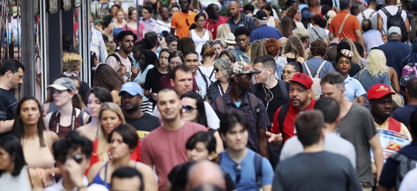 In this Aug. 22, 2019, photo, people walk through New York's Times Square. With just a few months left before America starts taking its biggest-ever self-portrait, the U.S. Census Bureau is grappling with a host of concerns about the headcount.