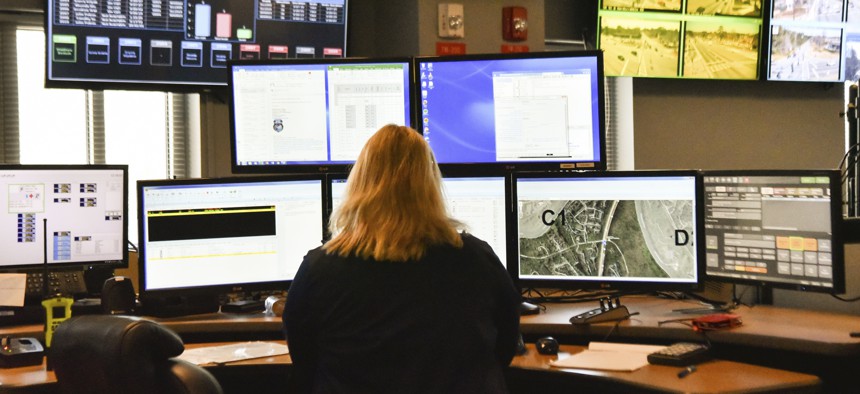 A dispatcher works at a desk station with a variety of screens used by those who take 911 emergency calls in Roswell, Ga.