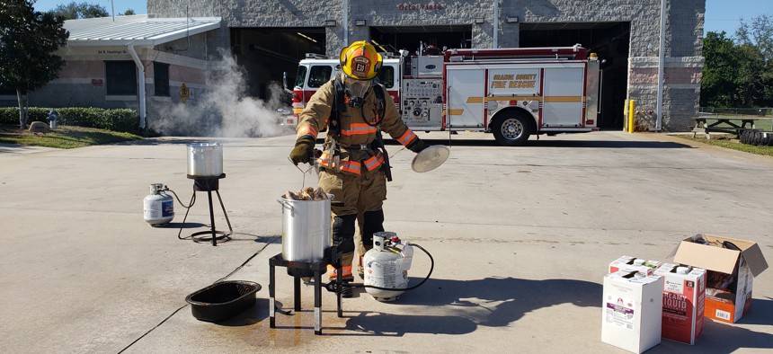 An firefighter from the Orange County Fire Rescue demonstrates how to deep fry a turkey as part of a public safety campaign. 