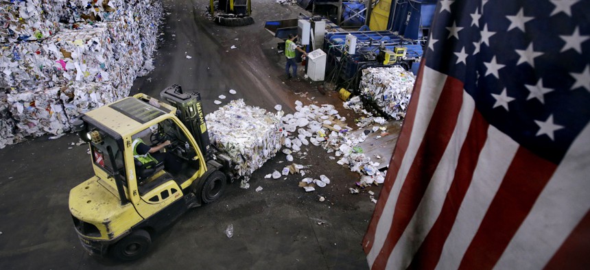 In this Thursday, Sept. 6, 2018, photo, a forklift takes a bundle of paper and cardboard off a conveyor belt at the end of a separating machine at EL Harvey & Sons, a waste and recycling company, in Westborough, Mass. 