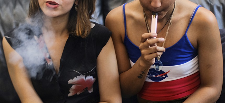In this Saturday, June 8, 2019, file photo, two women smoke cannabis vape pens at a party in Los Angeles. 