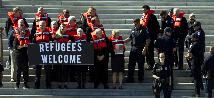 In this Oct. 15, 2019 file photo, faith leaders and members of human rights groups wearing a life vests symbolizing the life-saving program are arrested during a protest calling congress not to end refugee resettlement program.
