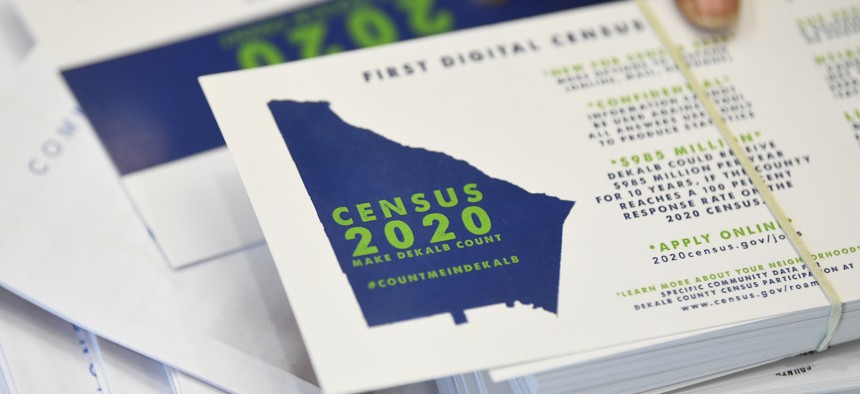 In this Aug. 13, 2019, file photo a worker gets ready to pass out instructions in how fill out the 2020 census during a town hall meeting in Lithonia, Ga. 