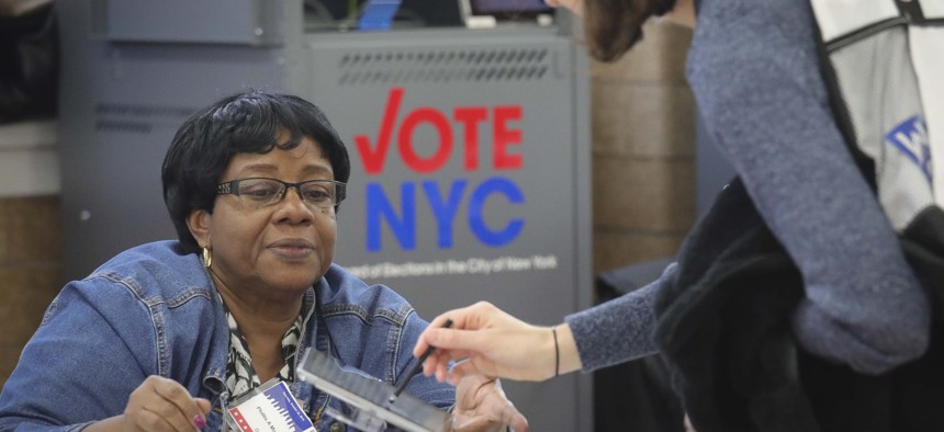 A polling site inspector checks in a voter during early voting last year in New York City. New York, along with a handful of other states, is expanding ballot access.