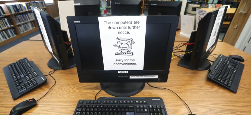 Signs on a bank of computers tell visitors that the machines are not working at the Wilmer, Texas, public library in August, after cyberattacks crippled nearly two dozen Texas cities.