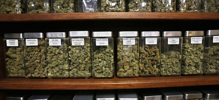 Glass containers display varieties of marijuana for sale on shelves at The Station, a retail and medical cannabis dispensary, in Boulder, Colorado. Gov. Jared Polis said his state is "years ahead" of other states in terms of marijuana legislation.
