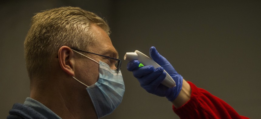 The temperature of a person arriving from China is checked as precautionary measures against the spreading of novel coronavirus at the airport in Budapest, Hungary.