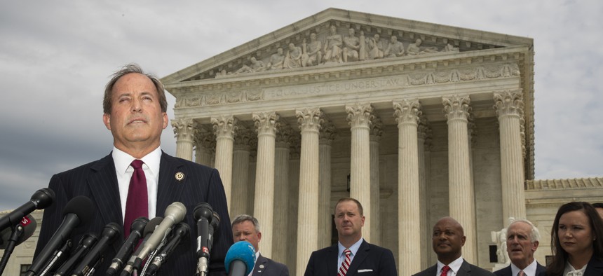 Texas Attorney General Ken Paxton and a bipartisan group of state attorneys general speaks to reporters in front of the U.S. Supreme Court in Washington, on Monday, Sept. 9, 2019.