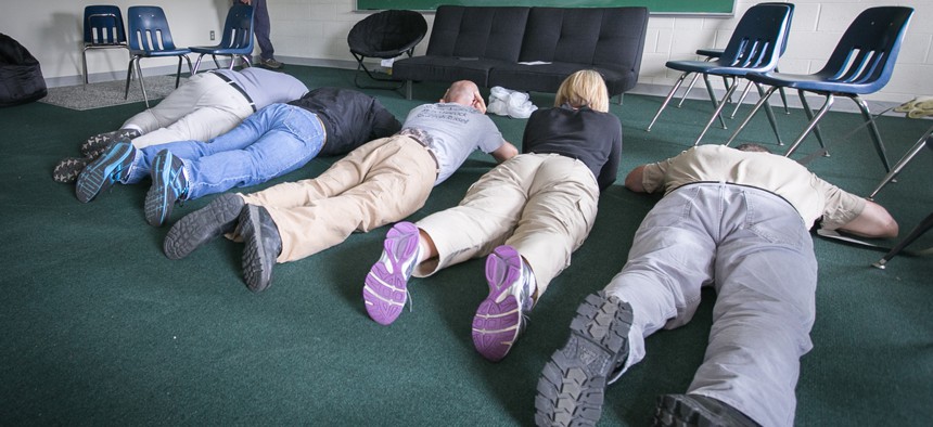 School employees play dead on the floor during an active shooter mock scenario in Rittman, Ohio, in June 2014.