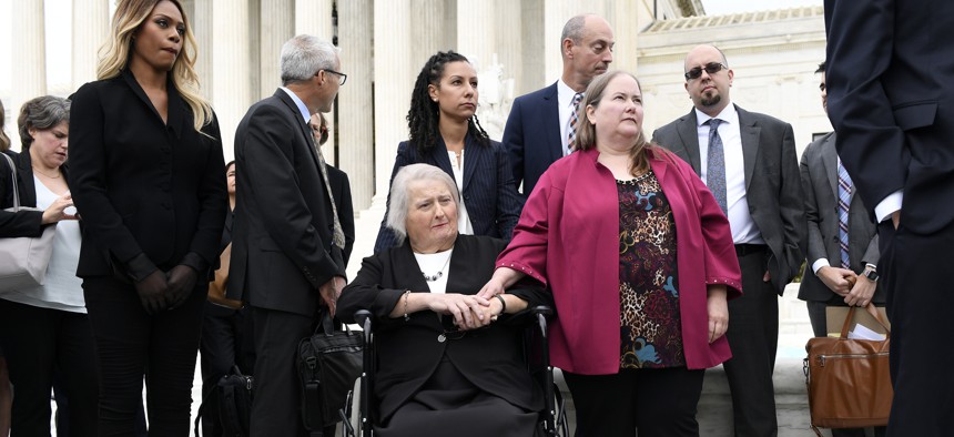 Aimee Stephens, seated center, listens during a news conference outside the Supreme Court. Stephens' case about her firing from a funeral home after her transition will determine transgender people's employment protections.