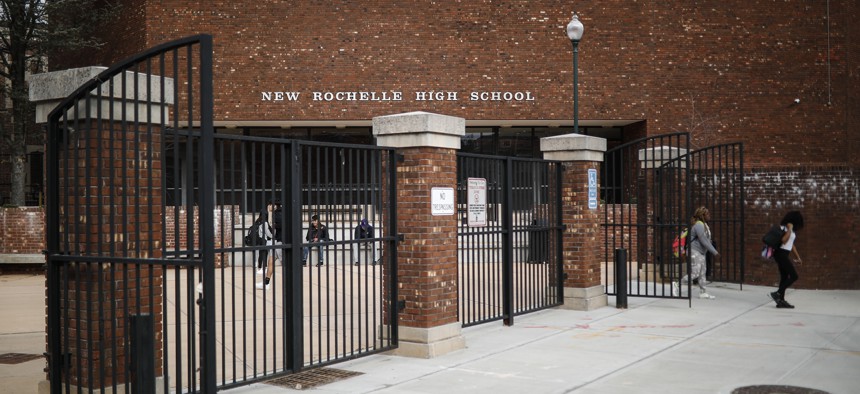 Students leave New Rochelle High School after classes are dismissed, Tuesday, March 10, 2020, in New York. State officials are shuttering schools and houses of worship for two weeks in part of the New York City suburb New Rochelle.