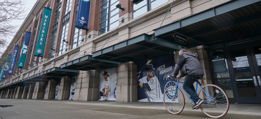 A bicyclist rides past T-Mobile Park in Seattle, where baseball's Seattle Mariners plays home games. In efforts to slow the spread of the COVID-19 coronavirus, Washington State Gov. Jay Inslee announced a ban on large public gatherings.