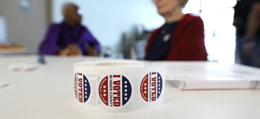 A roll of "I Voted" stickers rests next to ballots as poll workers wait for voters at a Jackson, Miss., precinct, Tuesday, March 10, 2020. 