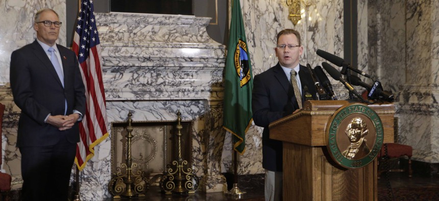 State Superintendent of Public Instruction Chris Reykdal, right, talks to the media about the decision to close all schools in the state in response to COVID-19, as Gov. Jay Inslee looks on, Friday, March 13, 2020, in Olympia, Wash. 