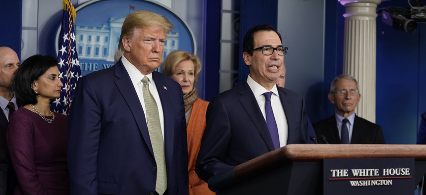 Treasury Secretary Steven Mnuchin speaks during a press briefing with the coronavirus task force, at the White House, Tuesday, March 17, 2020, in Washington, as President Donald Trump looks on.