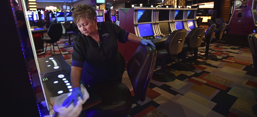 Antonia Garcia cleans slot machines inside the Planet Hollywood hotel-casino after all casinos in the state were ordered to shut down due to the coronavirus Wednesday, March 18, 2020, in Las Vegas.