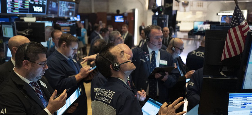Traders work at the New York Stock Exchange, Wednesday, March 18, 2020 in New York. Global stock markets have sunk in a third day of wild price swings after President Donald Trump promised to prop up the U.S. economy through the coronavirus outbreak.