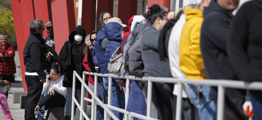 People wait in line for help with unemployment benefits at the One-Stop Career Center, Tuesday, March 17, 2020, in Las Vegas.