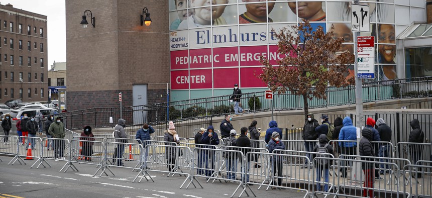 Patients wear personal protective equipment while maintaining social distancing as they wait in line for a COVID-19 test at Elmhurst Hospital Center, Wednesday, March 25, 2020, in New York. 