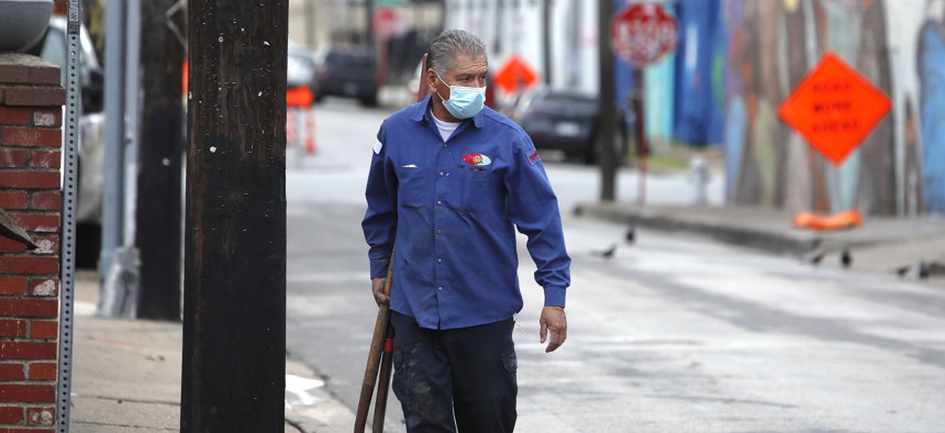 A worker wears a mask as he finishes up a task amid concerns of COVID-19 spreading in the Deep Ellum section of Dallas, Tuesday, March 31, 2020. 