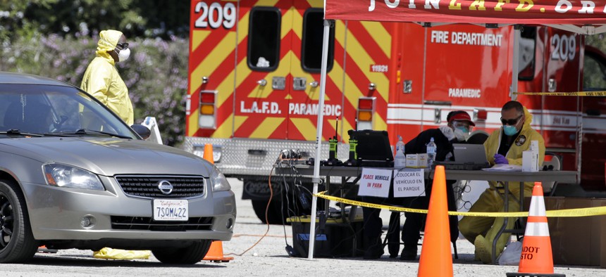 A coronavirus testing center for first responders operates in a parking lot for Dodger Stadium Monday, March 30, 2020, in Los Angeles.