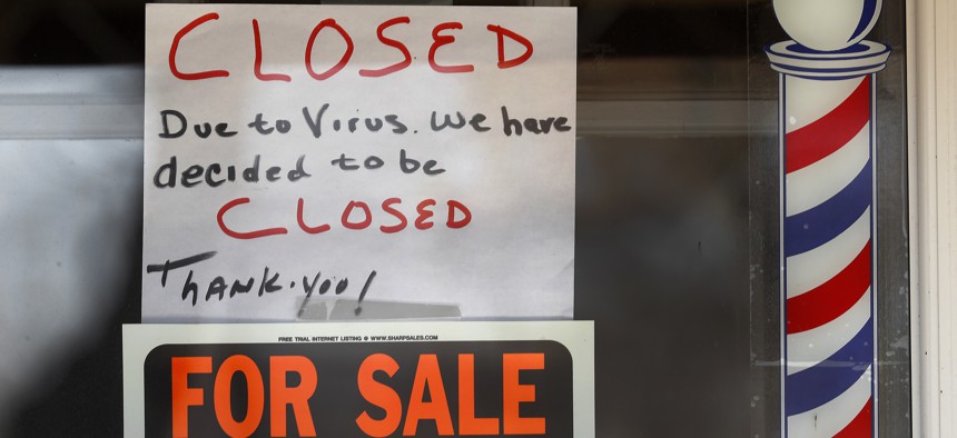 "For Sale By Owner" and "Closed Due to Virus" signs are displayed in the window of Images On Mack in Grosse Pointe Woods, Mich., Thursday, April 2, 2020. 