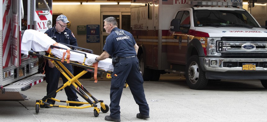 FDNY paramedics place an empty collapsible wheeled stretcher into an ambulance after delivering a patient into the emergency room at NewYork-Presbyterian Lower Manhattan Hospital, Wednesday, March 18, 2020, in New York.