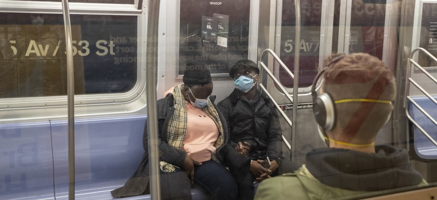 Riders on the New York City subway wear face masks. African Americans are more likely to live in dense urban areas that rely on public transportation.