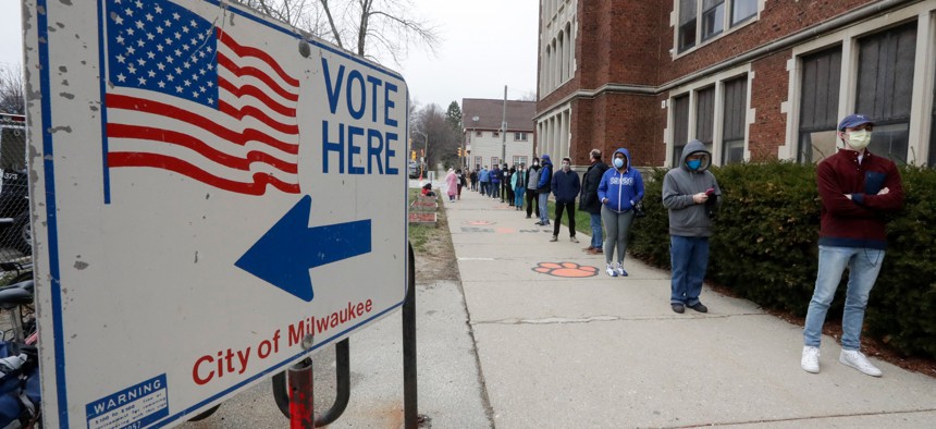 Voters line up at Riverside High School for Wisconsin's primary election Tuesday April 7, 2020, in Milwaukee.