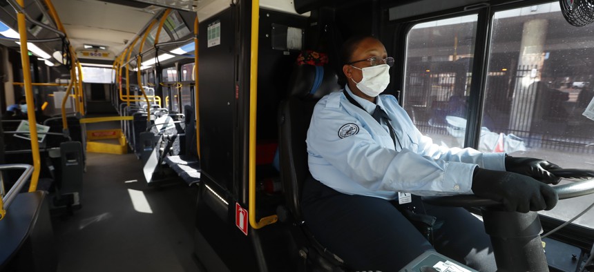 Detroit bus driver JaVita Brown wears gloves and a protective mask during the COVID-19 outbreak. City buses will have free surgical masks available to riders starting Wednesday, a new precaution the city is taking.