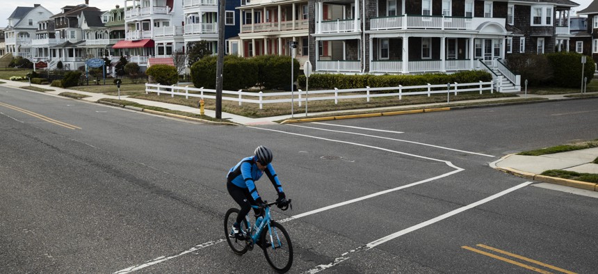 A cyclist rides a bicyle in Cape May, N.J., Wednesday, March 18, 2020.Some people who live in cities or their suburbs have been fleeing to their second homes at the shore to ride out the coronavirus near the beach.