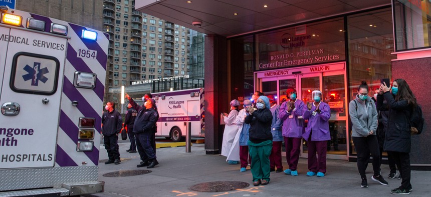 Doctors and nurses await an ambulance in New York.