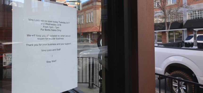 A sign at a wine shop in downtown Flagstaff, Ariz., Tuesday, March 17, 2020, lets customers know the shop will be closed temporarily. The mayor of Flagstaff ordered restrictions on restaurants and the closure of other businesses due to the coronavirus.