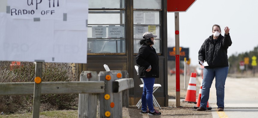 A New York State Department of Health worker instructs drivers to approach a kiosk at a COVID-19 drive-thru testing site at Jones Beach State Park on Long Island on March 18, 2020, in Wantagh, N.Y. 