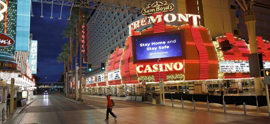 In this March 21, 2020, file photo, a man walks along a usually busy Fremont Street after casinos were ordered to shut down due to the coronavirus outbreak in Las Vegas.