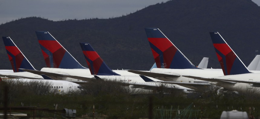 Tail fins of recently landed Delta Air Lines sit parked at Pinal Airpark on March 18, 2020, in Red Rock, Ariz.