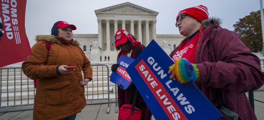 Activists gather outside the Supreme Court before the justices hear arguments in a case brought by gun owners in New York City, on Capitol Hill in Washington, Monday, Dec. 2, 2019.