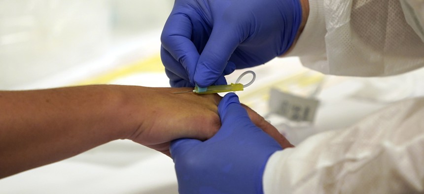 A Phlebotomist draws blood from a patient for COVID-19 antibody testing at Principle Health Systems and SynerGene Laboratory Tuesday, April 28, 2020, in Houston. 