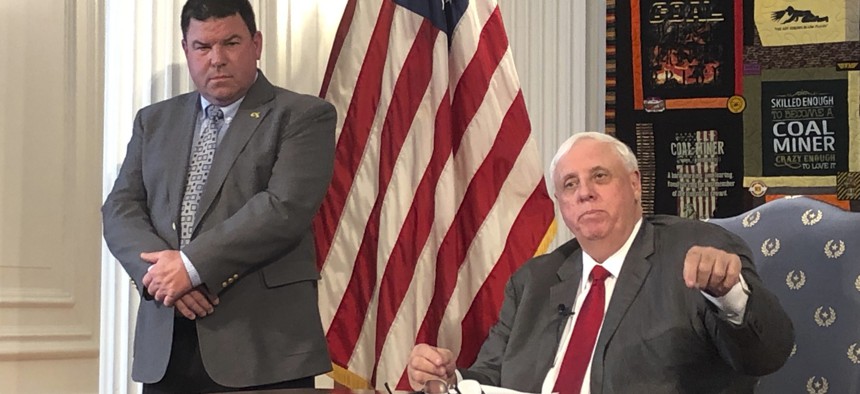 West Virginia Gov. Jim Justice, right, and West Virginia Secondary School Activities Commission Executive Director Bernie Dolan address a news conference Thursday, March 12, 2020, at the state Capitol in Charleston, W.Va. 