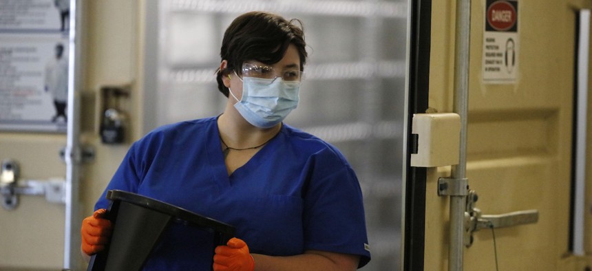 A worker carries a foot stool out of a Battelle N95 mask decontamination system on Friday, May 8, 2020, in Henderson, Colo. The state has received two of the cleaning units.