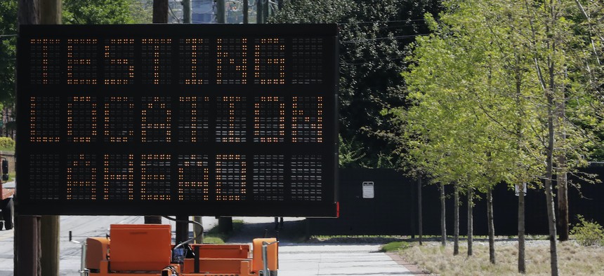 A sign reading "Testing Location Ahead" is seen near the COVID-19 testing area on Georgia Tech's campus, Monday, April 6, 2020, in Atlanta.