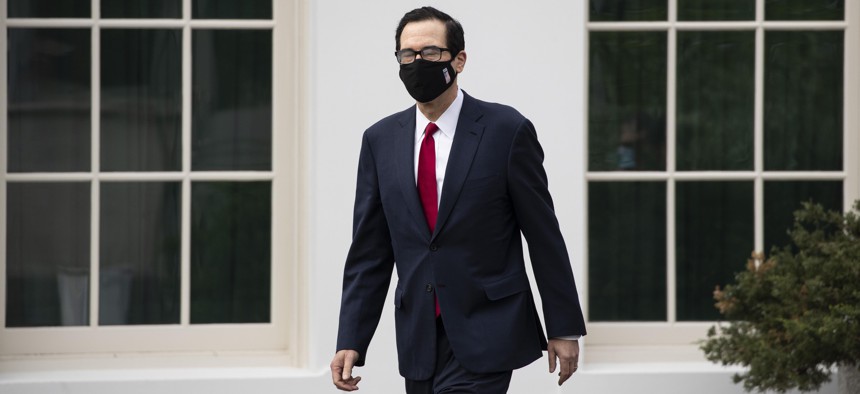 Treasury Secretary Steven Mnuchin wears a mask as he walks on the grounds of the White House, Thursday, May 14, 2020, in Washington.