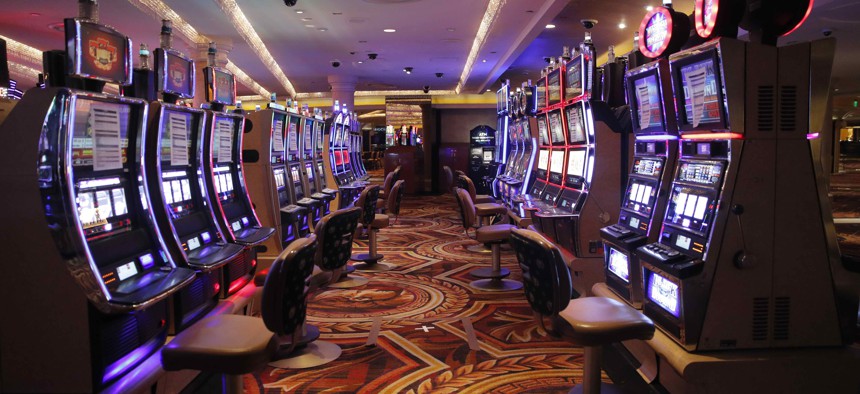 Chairs have been removed at some electronic slot machines to maintain social distancing between players at a closed Caesars Palace hotel and casino Thursday, May 21, 2020, in Las Vegas. Casinos are awaiting to reopen amid the coronavirus outbreak.