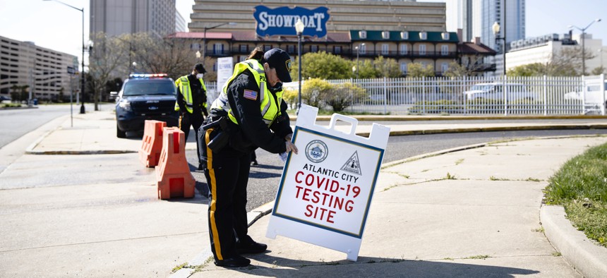 An officer sets out a sign ahead of the opening of a COVID-19 test location in a parking lot near the casinos in Atlantic City, N.J. on April 28, 2020. 