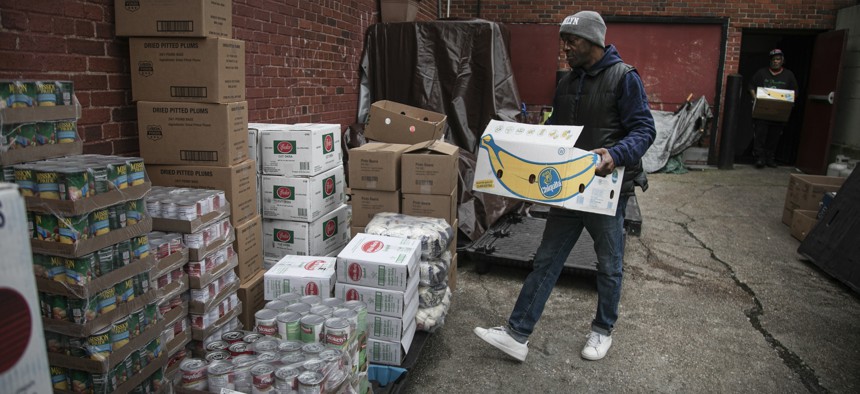 A volunteer at the St. Stephen Outreach carries food donations as he prepares to hand out food in the Brooklyn borough of New York on March 20, 2020. 