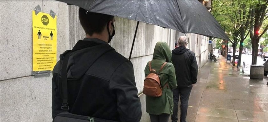 Potential grand jurors wait 6 feet apart to enter the Multnomah County Courthouse in Portland, Oregon, earlier this month. Courts around the country must figure out how to resume operations in a way that keeps employees and visitors safe.
