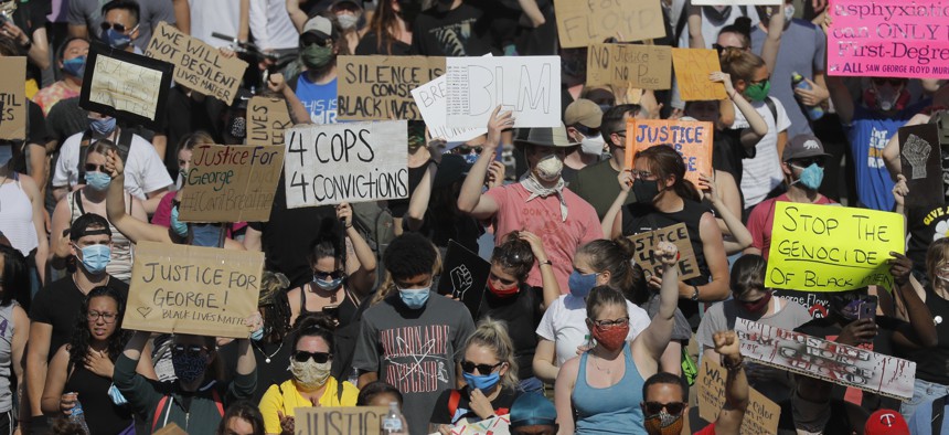 Demonstrators march on pavement, Sunday, May 31, 2020, in Minneapolis. Protests continued following the death of George Floyd, who died after being restrained by Minneapolis police officers on May 25. 
