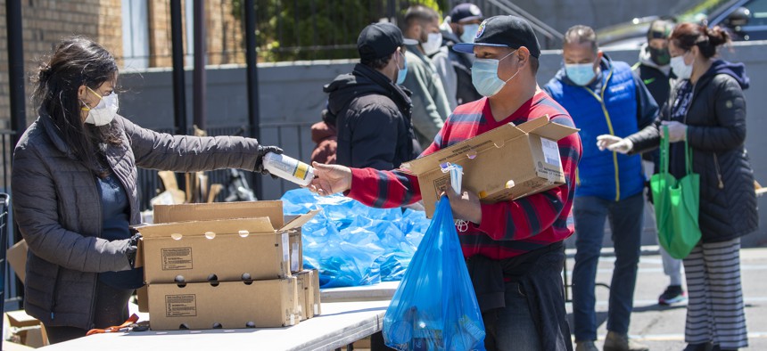 A volunteer distributes groceries at a church food pantry on May 12, 2020, in the Flushing neighborhood of the Queens borough of New York. 