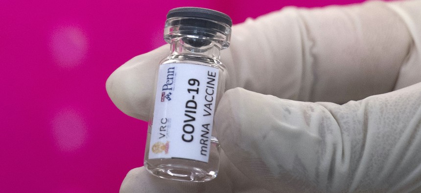 A lab technician holds a vile of a COVID-19 vaccine candidate during testing at the Chula Vaccine Research Center, run by Chulalongkorn University in Bangkok, Thailand, Monday, May 25, 2020.